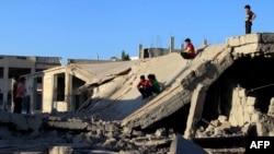 Syrian children slide down the rubble of a destroyed building in the rebel-held city of Daraa on September 12.