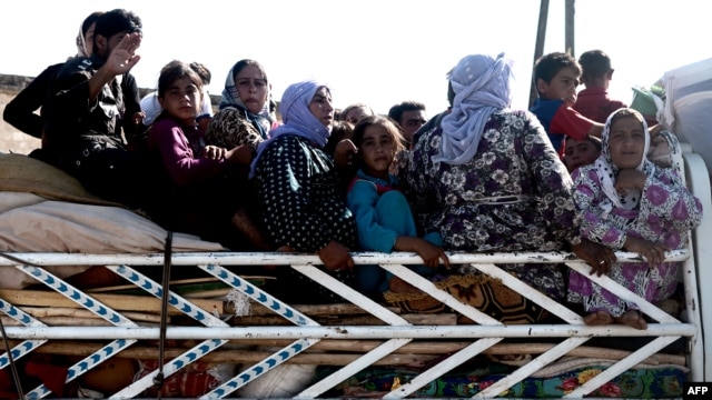 Syrians cross a checkpoint outside the northwestern Syrian city of Afrin, on the Syria-Turkey border, on August 23.
