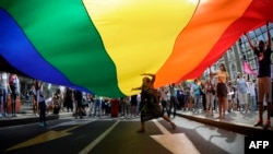 A woman dances under a huge rainbow flag during a gay pride parade in Belgrade on September 18.