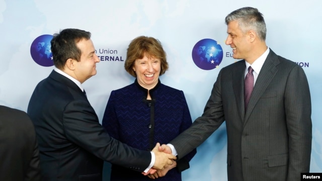Serbian Prime Minister Ivica Dacic (left) shakes hands with Kosovo's Prime Minister Hashim Thaci during a joint meeting with European Union foreign-policy chief Catherine Ashton in Brussels on December 13.