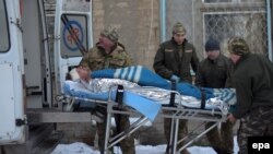 Members of a Ukrainian military medical unit carry an injured soldier from hospital to an ambulance as they prepare to evacuate from the eastern town of Avdiyivka on January 31.