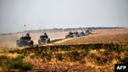 Turkish Army tanks drive near the Syrian border after the August launch of the military campaign.
