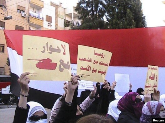 Antigovernment demonstrators march through the streets of Homs earlier this month.