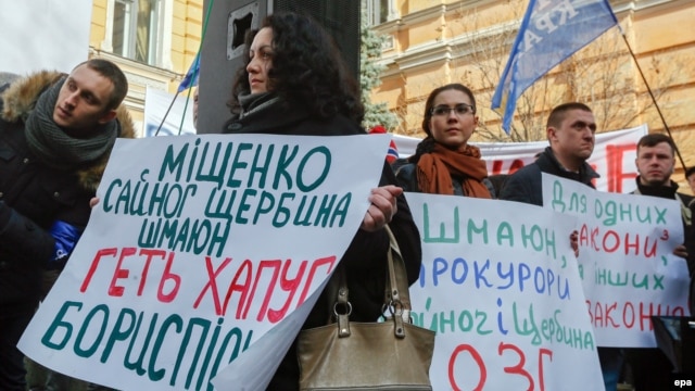 Ukrainian activists hold placards during their rally in front of the presidential office in Kyiv, demanding the resignation of Prosecutor-General Viktor Shokin.