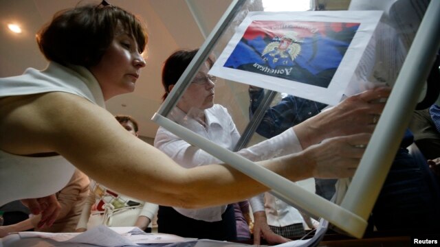 Members of a local separatist election commission empty a ballot box as they start counting votes of the referendum on the status of Donetsk region in Donetsk on May 11.