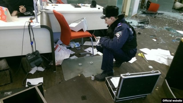 Police inspect the damaged Alfa Bank in Kyiv after the attack.