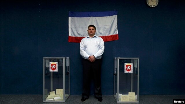 An official stands between two ballot boxes inside a polling station during the disputed referendum on the status of Ukraine's Crimea region in Bakhchisaray on March 16.