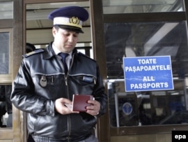 A customs officer checks a passport at the Romanian border with Moldova in Albita. (file photo)