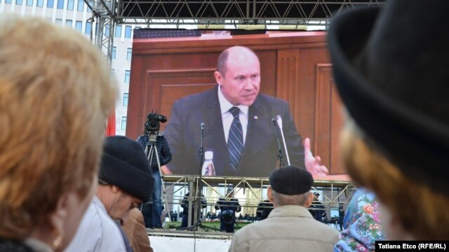 Prime Minister Valeriu Strelet is seen on a screen outside the parliament building in Chisinau as he speaks inside shortly before he was dismissed on October 29.