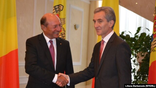 Moldovan Prime Minister Iurie Leanca (right) greets Romanian President Traian Basescu in Chisinau on July 17.