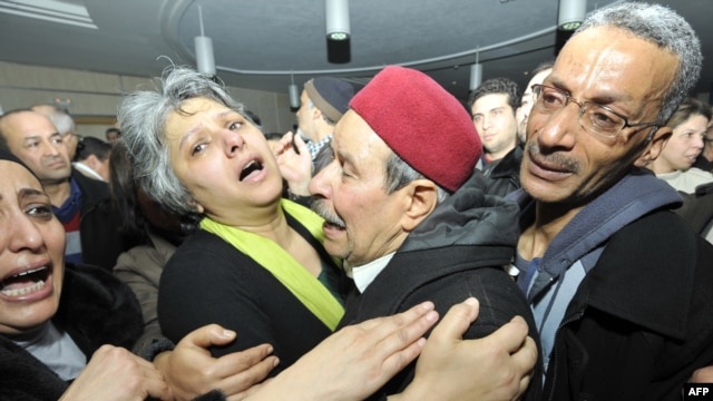 Basma Khalfaoui Belaid, wife of assassinated Tunisian opposition leader and outspoken government critic Chokri Belaid, mourns with Chokri's father after his killing in Tunis on February 6.
