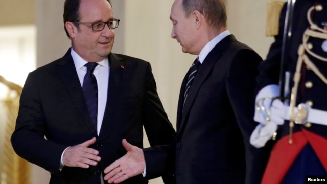 French President Francois Hollande (left) shakes hands with Russian President Vladimir Putin after a summit on the Ukraine crisis at the Elysee Palace in Paris on October 2.