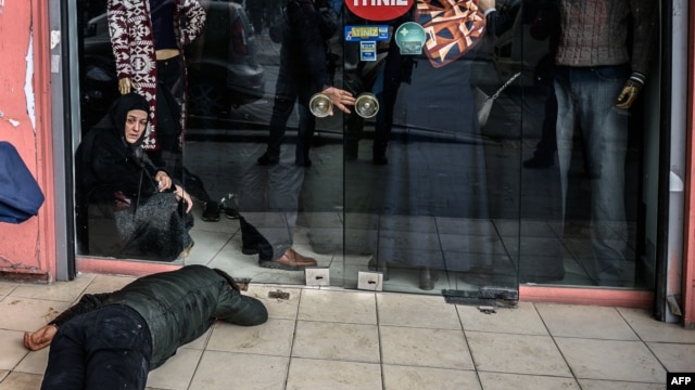 A man lies on the pavement after Turkish antiriot police officers fired tear gas to disperse supporters in front of the headquarters of the Turkish daily newspaper Zaman in Istanbul on March 5.