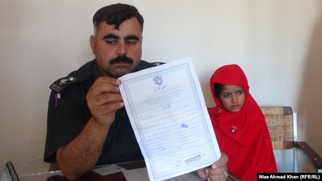 A police officer and a 6-year-old bride in Swat, in northwestern Pakistan, in a photo from a separate case from late October.