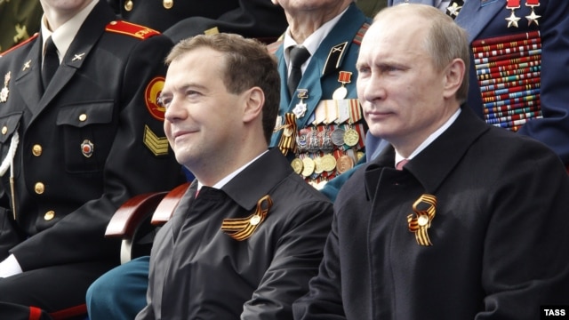 Dmitry Medvedev (left) and Vladimir Putin watch a military parade on Red Square on Victory Day in Moscow in 2011.