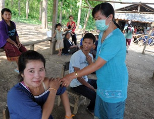 A woman receives a shot at a village in northern Laos's Luang Prabang province, May 4, 2012.