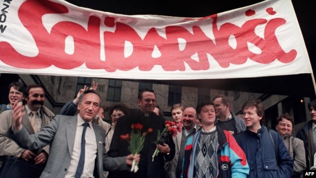 Tadeusz Mazowiecki (in suit and tie) and other members and supporters of Solidarnost jubilate after their Polish trade union was officially legalized again by a court, in Warsaw, on April 17, 1989.