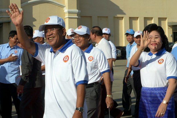 Hun Sen (L) and his wife Bun Rany (R) greet supporters in Phnom Penh, June 27, 2013.