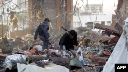 A Yemeni collects items amid the rubble of a destroyed building following reported air strikes by Saudi-led coalition airplanes on the capital Sanaa on October 8.