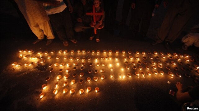 Members of the Pakistani Christian community light oil lamps during a protest rally to condemn a deadly suicide attack on a Christian church in Peshawar on September 22, which killed more that 80 people.