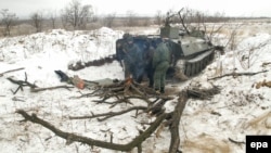 Pro-Russia rebels stand next to an armored military vehicle on the front line near the eastern Ukrainian town of Svitlodarsk on December 19.