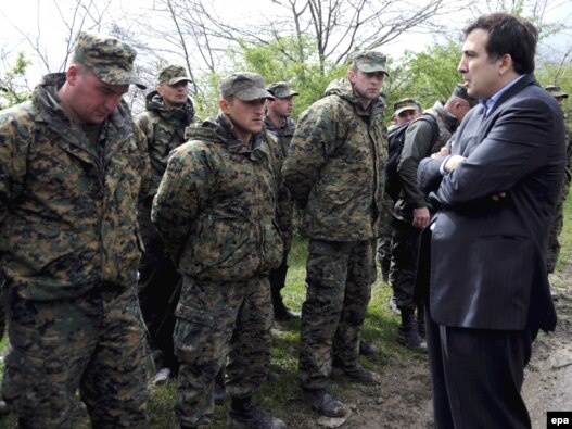 Georgian President Mikheil Saakashvili (right) talks with soldiers who took part in a mutiny at the Mukhrovani base last year. The opposition claims the mutiny was a distraction planned by the government.