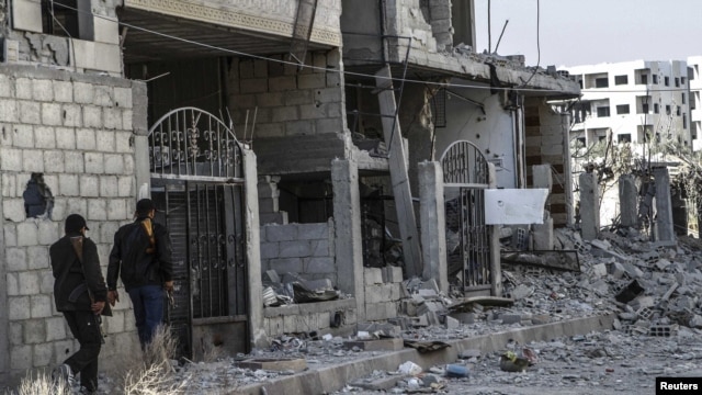 Free Syrian Army fighters inspect the damage after an air strike by government forces in Ghouta, east of Damascus, on November 17.