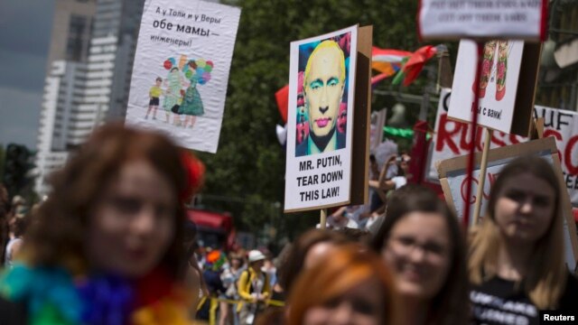 People carry posters denouncing Russia's policies on homosexuality at a parade in Berlin on June 22.