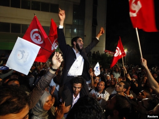 Ennahda supporters celebrate outside the group's headquarters in Tunis on October 25.