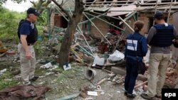 OSCE observers inspect a private building that was destroyed by shelling in Avdiyivka last month.