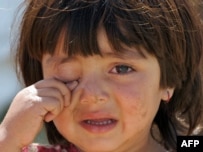 A girl cries outside her tent at a camp in Swabi after her family fled Swat.