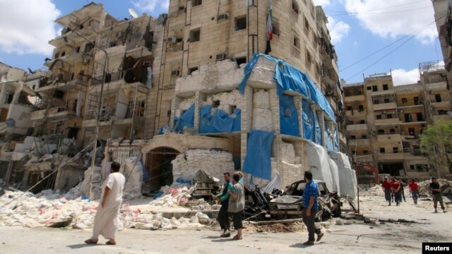 People inspect the damage at the Al-Quds hospital in Aleppo after it was hit by air strikes.