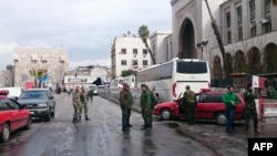 Syrian security forces cordon off the area following a deadly suicide bombing at a Damascus courthouse on March 15.