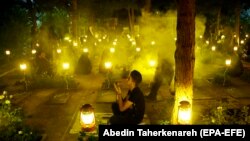 Iranians pray around the graves of 'martyrs' in a religious ceremony during the holy fasting month of Ramadan at the Behesht-Zahra cemetery in Tehran.