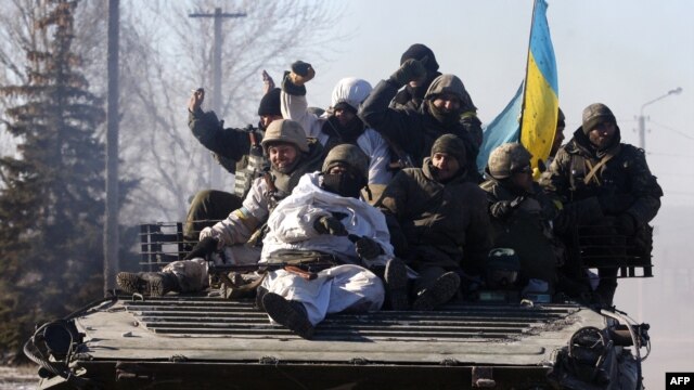 Ukrainian soldiers ride an armored personnel carrier as they leave the eastern Ukrainian city of Debaltseve on February 18.