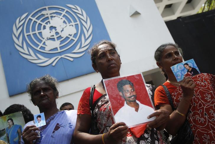 Sri Lankan Tamil women hold up photographs of their missing family members as they wait to hand over a petition to the UN head office in Colombo on March 13, 2013.