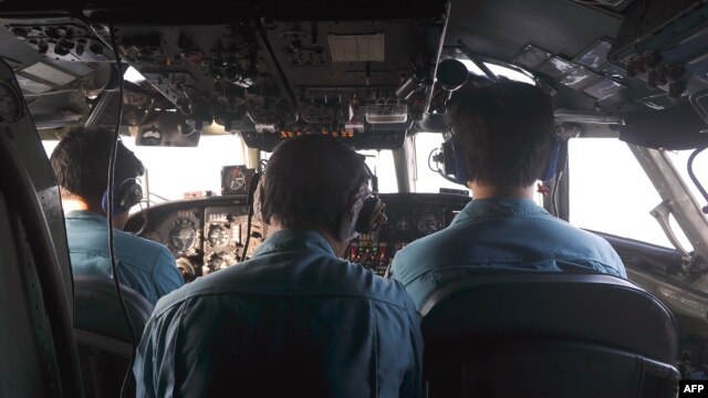The crew of an airborne Soviet-made AN-26 being used as a search aircraft by the Vietnamese Air Force look for traces of the missing Malaysia Airlines flight MH370 over the South China Sea.