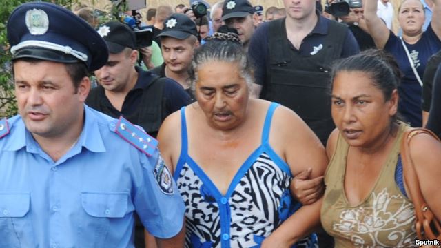 Police officers attempt to pacify local residents in the village of Loshchynivka in the Odesa region, where clashes and anti-Romany riots took place following the killing of a 9-year-old child.