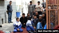 Uyghur children join the adults at a mosque for Friday Prayers in Urumqi, the capital of Xinjiang.