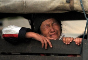 A refugee sits inside a truck during the operation to deport Hmong from a camp in Thailand's Petchabun province, Dec. 28, 2009.