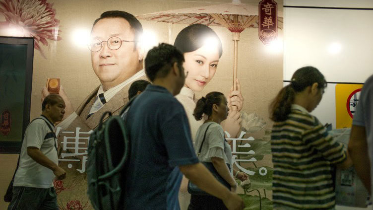 People walking past advertising as they cross the Chinese border from the city of Shenzhen into Hong Kong, Sept. 6, 2017.