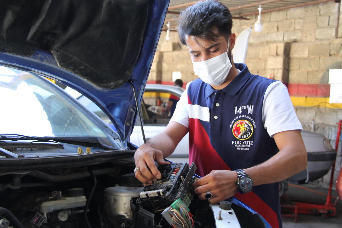 Iran. Iranian entrepreneur and mechanic work in an automobile repair shop which employs refugees