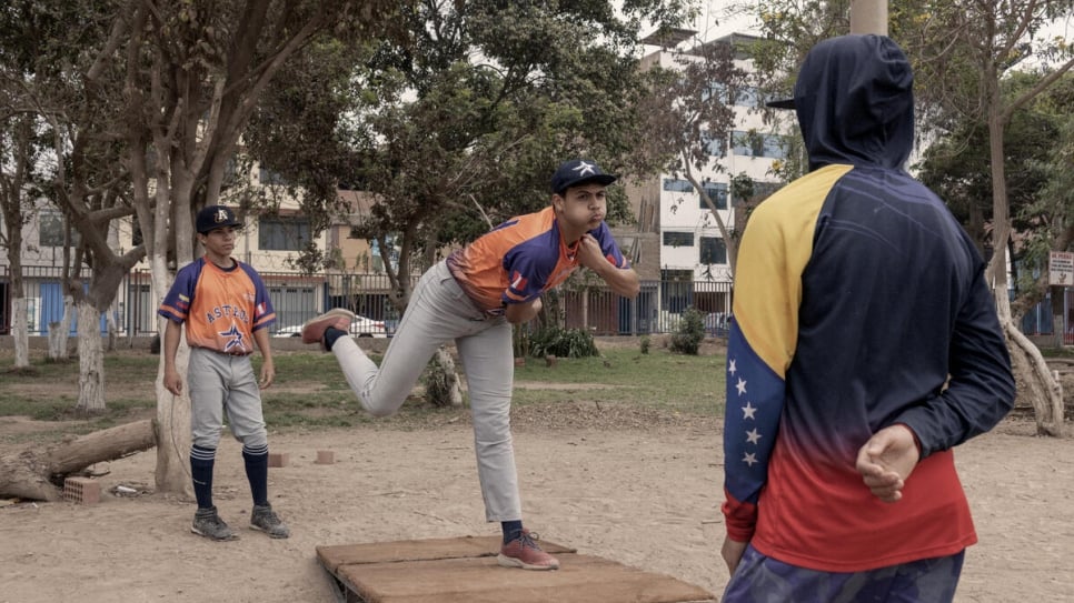 A young baseball player pitches a ball