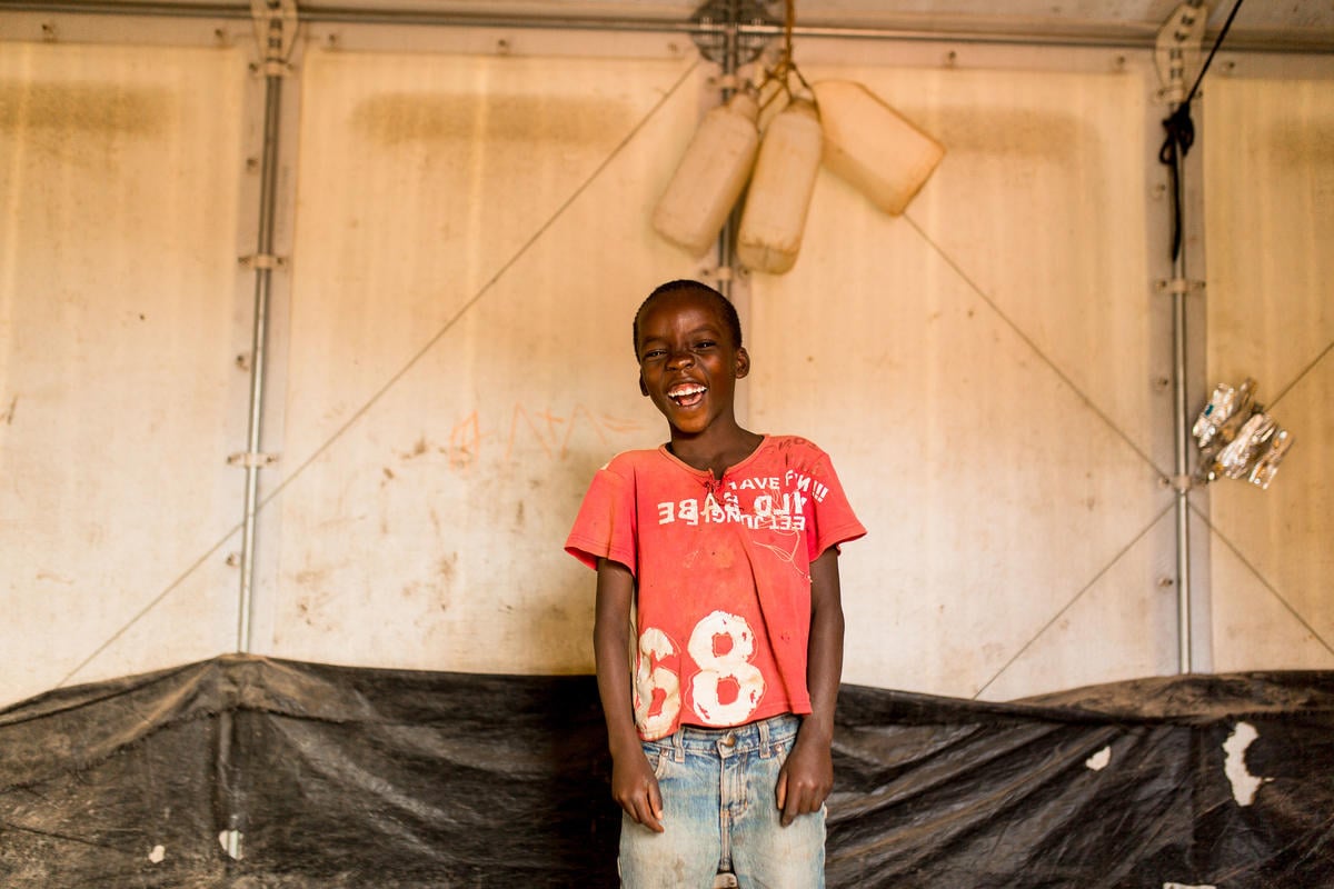 Tanzania. Velarie Ntahonicaye and her family with their Refugee Housing Unit (RHU) in Kigoma Refugee Camp