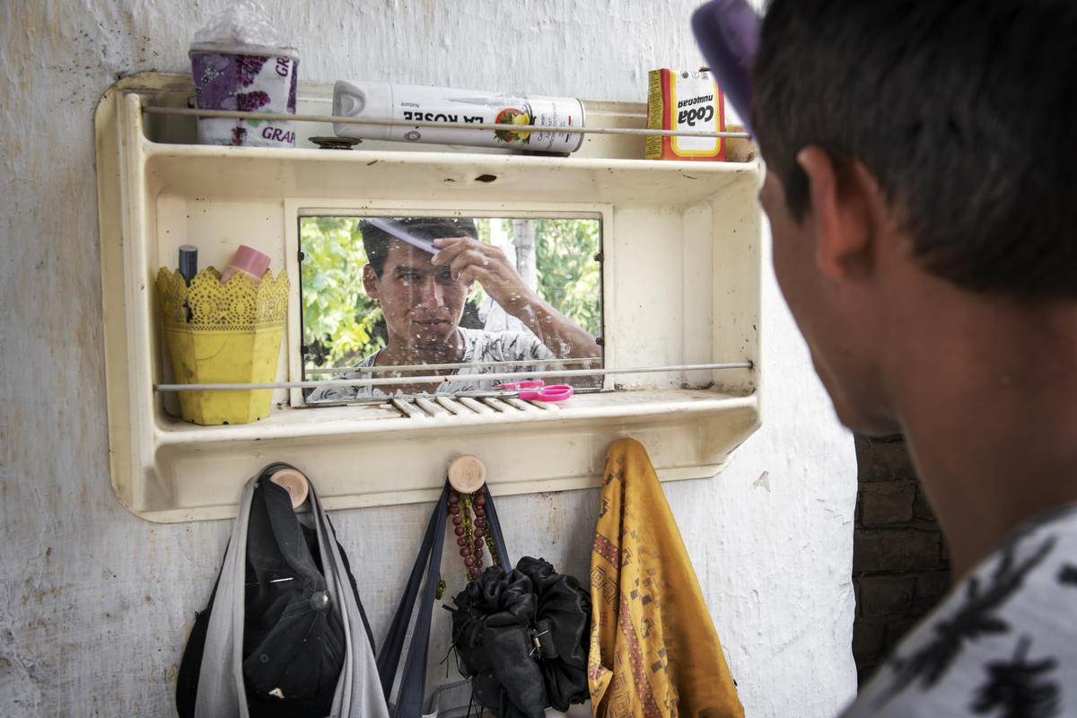 Kyrgyzstan. Nazir Khatamov, 21, combing his hair.