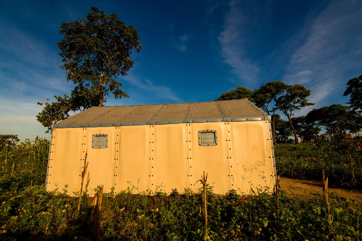 Tanzania. Velarie Ntahonicaye and her family with their Refugee Housing Unit (RHU) in Kigoma Refugee Camp